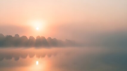 Obraz premium Serene lake landscape at sunrise with misty fog