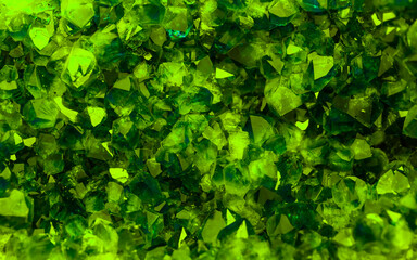 Obraz premium Green crystal mineral stone. Gems. Mineral crystals in the natural environment. Texture of precious and semiprecious stones. Seamless background with copy space colored shiny surface of precious stone