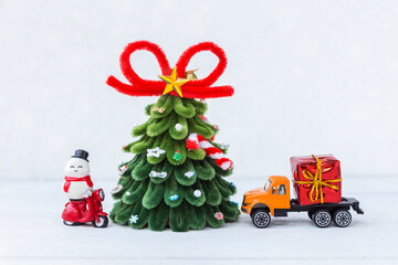 Snowman on red scooter with Christmas tree and gift box on orange truck on white background, Christmas card background idea