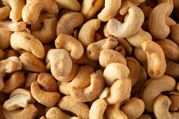 Fototapeta premium A top down view of a pile of salted whole cashew, as a background.