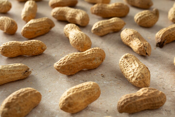 Obraz premium A closeup view of a scattered pile roasted peanuts.