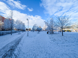 Street in the city with snow and ice. Snow-covered sidewalks in winter on the square.