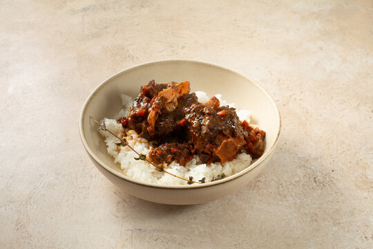 A view of a plate of braised oxtail and rice.