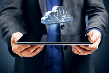Businessman holding tablet with cloud computing symbol representing digital data storage and virtual network infrastructure concept.