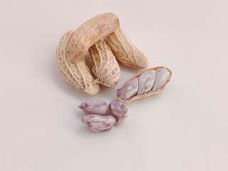Boiled peanuts, both shelled and unshelled, on a white background.