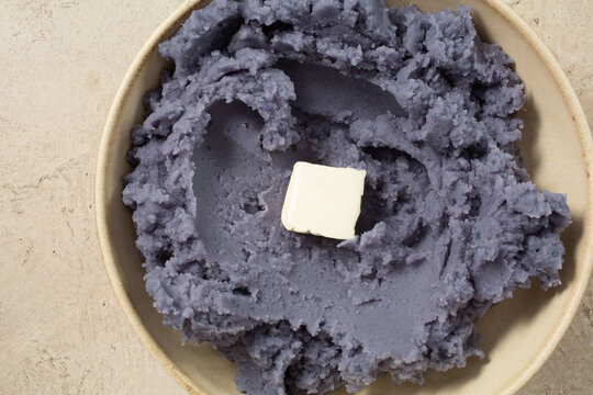 A top down view of a plate of mashed purple potato.