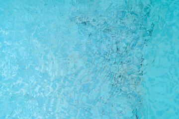 close-up view of blue water with ripples and reflections, suitable as a background. The water...