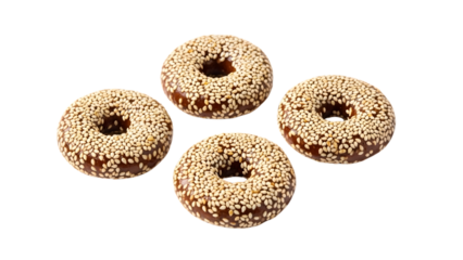 Four ring-shaped donuts covered in sesame seeds, arranged in a diamond pattern on a transparent background, sweet pastry composition.