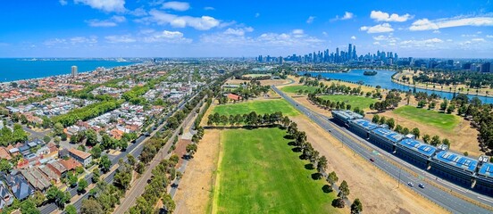 Fototapeta premium An aerial view of the Albert Park Grand Prix Circuit infrastructure, featuring the pit lane buildings and track. The view extends over Albert Park Lake toward