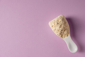 Spoon with protein on colored background.
