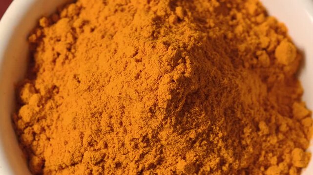 Turmeric powder in a white cup.