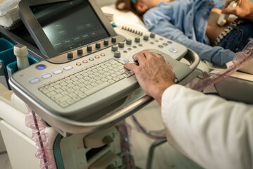 Obraz premium Doctor operating ultrasound machine on a child patient for medical examination