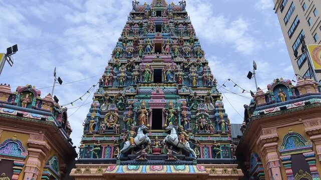 Kuala Lumpur, Malaysia - June 18, 2025: Close-up and facade of the Hindu temple Sri Maha Mariamman Dhevasthanam with prayer flags and sculptures of deities, in Chinatown. 4К