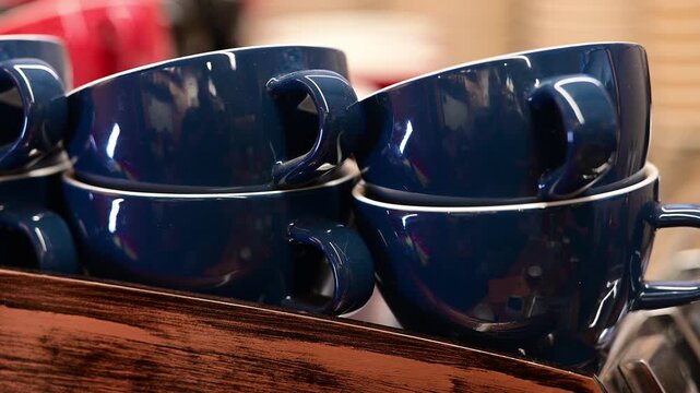 Close-up of stacked blue coffee cups on a wooden shelf