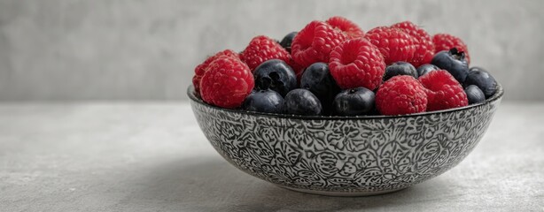 The Bowl of Fresh Raspberries and Blueberries on a Gray Concrete Surface