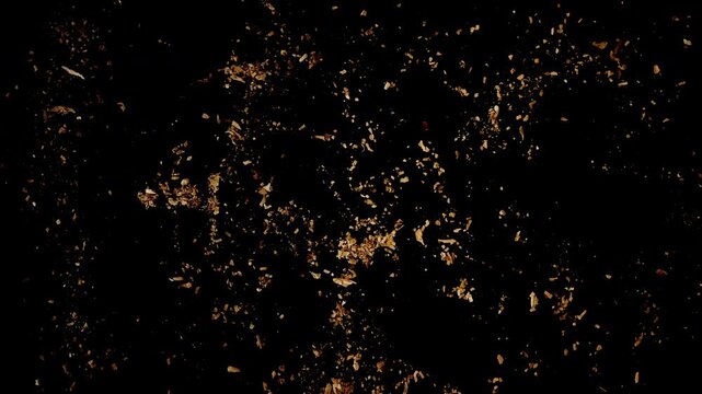 Broken cigarette with scattered tobacco crumbs on black background in top-down view with visible texture and sharp contrast