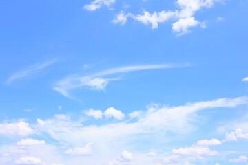 Obraz premium Beautiful clear blue sky with white fluffy clouds on a sunny day perfect for background, texture, wallpaper, and nature concept