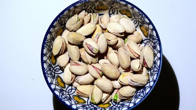 Pistachos tostados y salados dentro de un bol de ceramica
