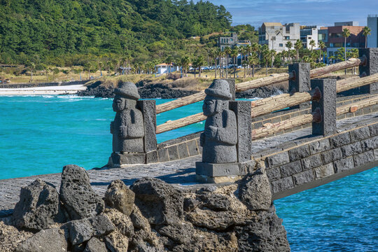 Stone bridge in Hamdeok Beach fronted by traditional dols, Jeju Island, South Korea