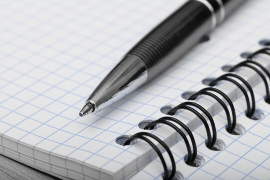 school and office supplies ballpoint pen lying on a notebook