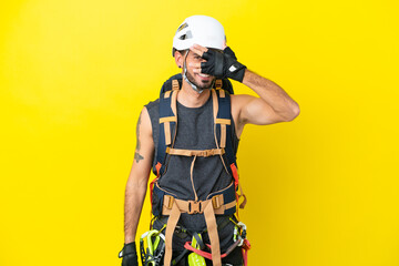 Fototapeta premium Young caucasian rock climber man isolated on yellow background covering eyes by hands and smiling