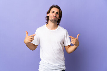 Fototapeta premium Young handsome man isolated on purple background proud and self-satisfied