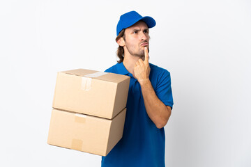 Delivery man isolated on white background having doubts while looking up
