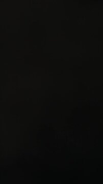 Cracked raw egg presses yolk through fractured shell with white dripping downward in food prep context