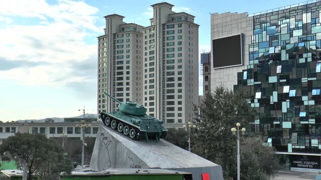 MONGOLIA, ULAANBAATAR - august 30, 2013: A monument in the form of a Soviet T-34 tank at the foot of the Zaisan memorial, with buildings in the background on a cloudy summer evening.