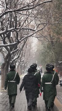 Chinese soldiers walking in snow, Beijing, China.