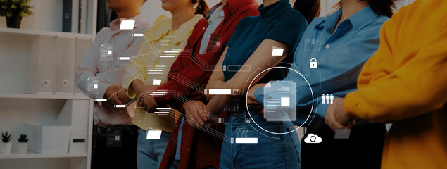 A group of diverse professionals stands together in a modern office, showcasing collaboration with a digital interface that highlights essential business concepts and teamwork. Trope