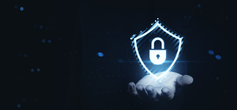 Digital security shield with lock icon hologram hovering above open hand on futuristic background representing cybersecurity concept and protection. - Powered by Adobe