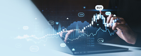 Businessman analyzing forex graph and market investment chart with futuristic financial hologram interface on digital screen in modern workspace setup.