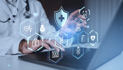 Doctor using laptop with digital medical icons and healthcare holograms on futuristic blue background concept of modern digital health technology.