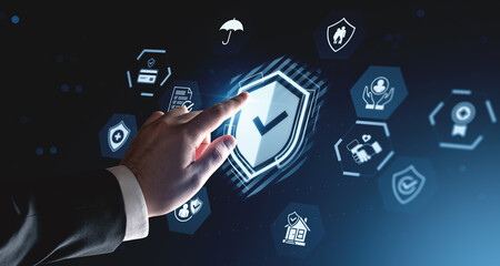 Futuristic hand interacting with digital security shield hologram in virtual interface concept on dark blue background with technology icons.