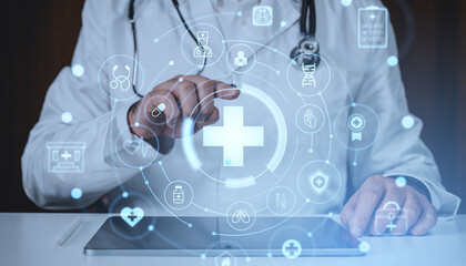 Doctor interacting with digital healthcare hologram interface on tablet in futuristic medical concept background with glowing symbols and icons.