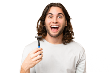 Young handsome man shaving his beard over isolated background with surprise and shocked facial expression