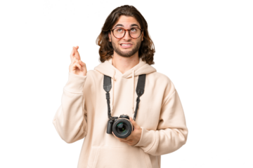 Young photographer man over isolated background with fingers crossing and wishing the best