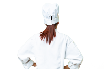 Young woman Chef over isolated chroma key background in back position