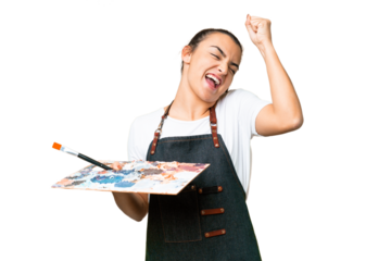 Young artist woman holding a palette over isolated chroma key background celebrating a victory