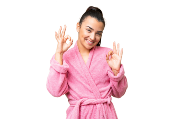 Young woman in a bathrobe over isolated chroma key background showing an ok sign with fingers
