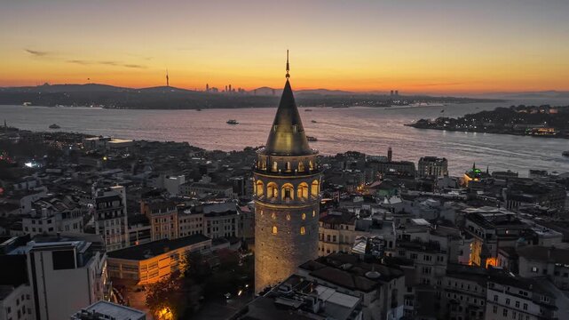 Galata Tower illuminated against the red morning sky, Istanbul, Turkey. Aerial view of Galata Tower and Istanbul skyline at sunrise over the Bosphorus. UHD HDR shot 