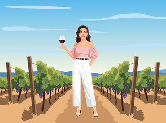 woman in white pants and a pink top stands confidently in a vineyard row, holding a glass of red wine under a clear blue sky.