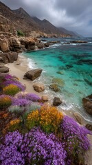 Vibrant wildflowers carpet sandy beach by turquoise ocean, rugged mountains