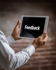 An African American man holding a tablet with the word "Feedback" displayed on the screen.