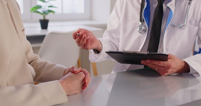 Woman talking to male doctor or nurse in office during medical examination. Man physician listening to the patient's complaints in clinic. Medicine concept. 4k video. Slow motion video.
