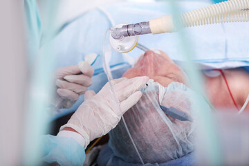 Preparing the patient for surgery. Introduction to anesthesia. General anesthesia. A breathing mask in the hands of a doctor.