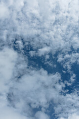 Obraz premium Blue Sky with Soft White Clouds Under Natural Daylight – High-Resolution Cloudscape Background for Nature, Weather, and Sky Photography