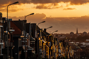 Urban environment and residential neighborhood architecture. Row of houses along a street in warm sunset light. 