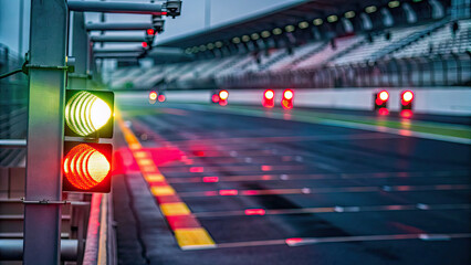 A close-up of illuminated lights on empty track concept. Illuminated traffic lights signaling the start of a race track.